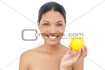 Cheerful black haired model holding orange