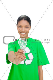 Cheerful model wearing recycling tshirt holding light bulb