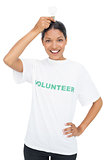 Smiling model wearing volunteer tshirt holding light bulb above her head