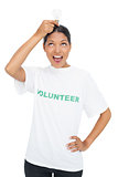 Happy model wearing volunteer tshirt holding light bulb above her head