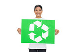 Smiling young woman holding recycling sign