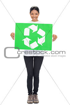 Smiling young woman holding recycling sign