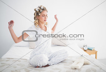 Gorgeous blonde stretching on cosy bed
