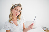 Cheerful gorgeous blonde wearing hair curlers kissing at camera