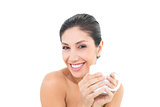 Pretty brunette holding a white mug and smiling at camera