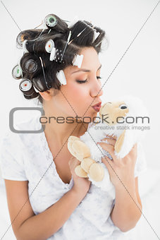 Brunette in hair rollers kissing sheep teddy