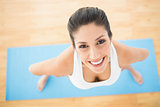 Happy woman standing on blue exercise mat