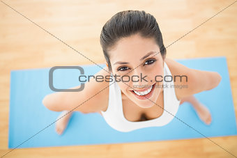 Happy woman standing on blue exercise mat