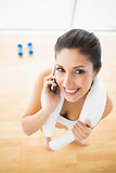 Fit woman on the phone smiling at camera