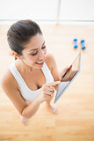 Fit woman using tablet taking a break from workout