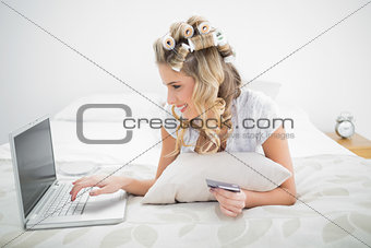 Cheerful cute blonde shopping online using laptop