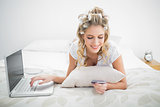 Smiling natural blonde shopping online using laptop
