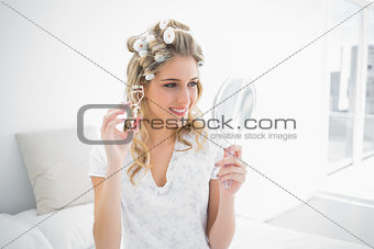 Cheerful natural blonde holding eyelash curler