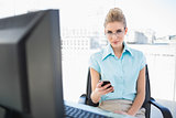 Relaxed businesswoman wearing glasses text messaging