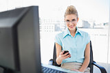 Smiling businesswoman wearing glasses text messaging