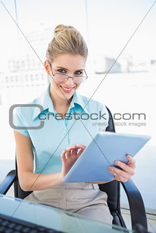 Smiling businesswoman wearing glasses using tablet