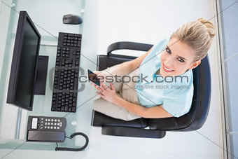 Overhead view of smiling businesswoman text messaging