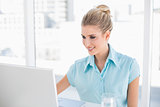 Cheerful well dressed businesswoman using laptop