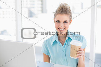 Happy well dressed businesswoman holding coffee