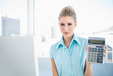 Frowning elegant woman showing calculator