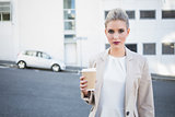 Serious stylish businesswoman holding coffee