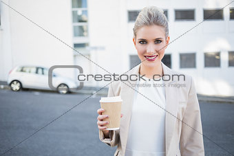 Cheerful stylish businesswoman holding coffee