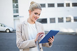 Smiling stylish businesswoman scrolling on digital tablet