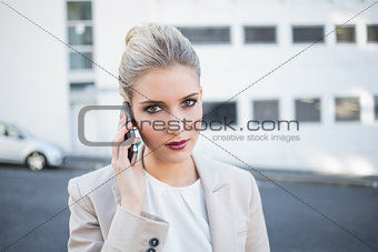 Serious stylish businesswoman having a phone call
