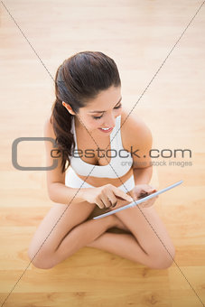 Fit woman sitting and using her tablet pc