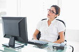 Serious businesswoman sitting at her desk looking at computer