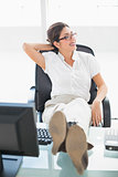 Relaxed businesswoman sitting at her desk with her feet up