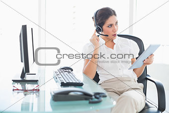 Focused call centre agent using her digital tablet on a call