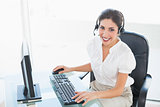 Happy call centre agent working on computer while on a call