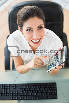 Happy accountant holding a calculator looking at camera
