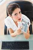 Serious accountant holding a calculator looking at camera