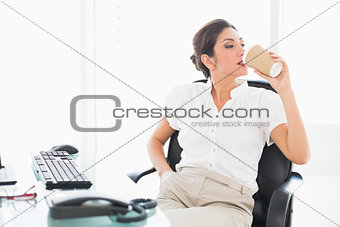 Relaxed businesswoman drinking a coffee at her desk