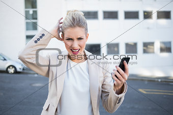 Furious stylish businesswoman holding her phone