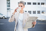 Serious stylish businesswoman drinking coffee