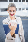 Smiling stylish businesswoman holding tablet computer