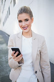 Smiling attractive businesswoman sending a text