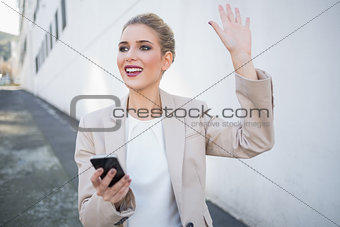 Cheerful attractive businesswoman waving