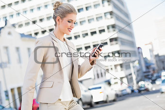 Smiling gorgeous businesswoman text messaging