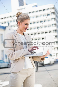 Cheerful elegant businesswoman working on laptop