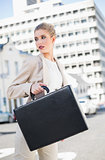 Serious elegant businesswoman holding briefcase