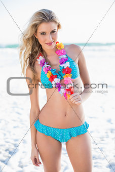 Smiling sexy blonde in bikini wearing hawaii necklace