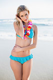 Sexy blonde in bikini wearing hawaii necklace posing