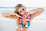 Sexy peaceful blonde in bikini wearing hawaii necklace posing