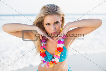 Sexy happy blonde in bikini wearing hawaii necklace posing