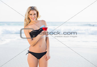 Gorgeous blonde in elegant bikini holding cocktail