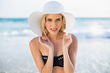 Happy sexy blonde in elegant bikini wearing straw hat posing